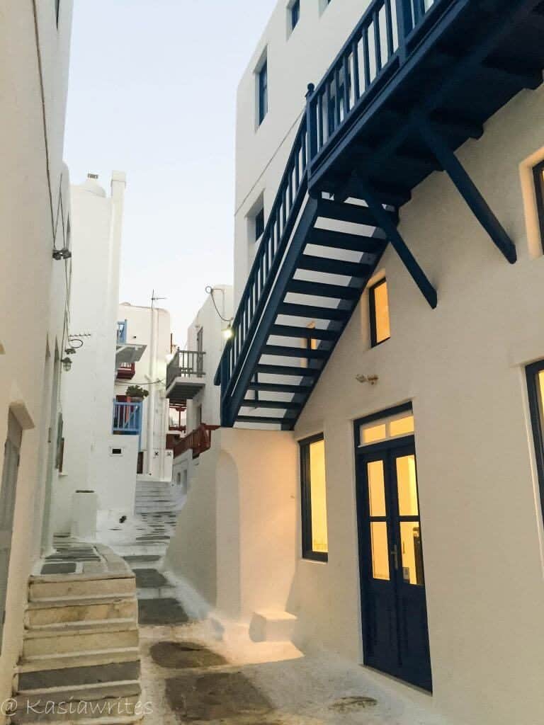 streets of mykonos with white houses and blue trim