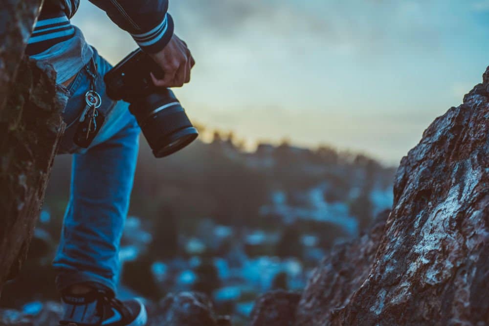 photographer holding a camera on a mountain
