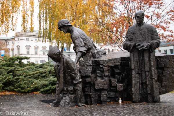 statue of soldiers with a priest overlooking 