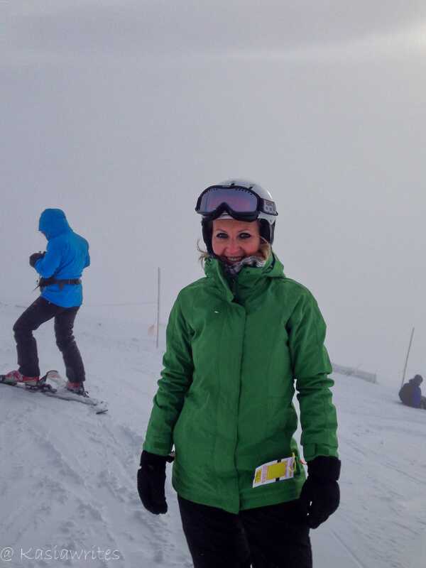 Woman in a green jacket snowboarding in Banff