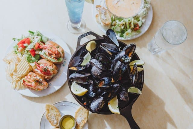 mussels in a dish with lobster rolls 