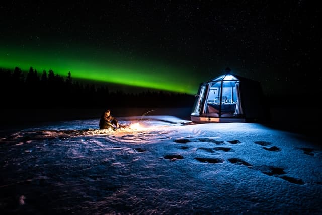 Igloo hotel with green Northern Lights in the sky